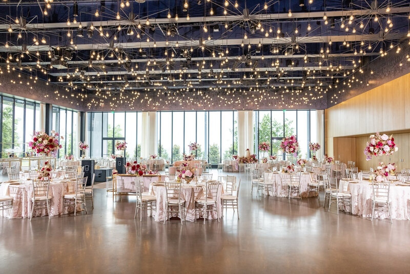 Ballroom with cascading string lights and pink florals