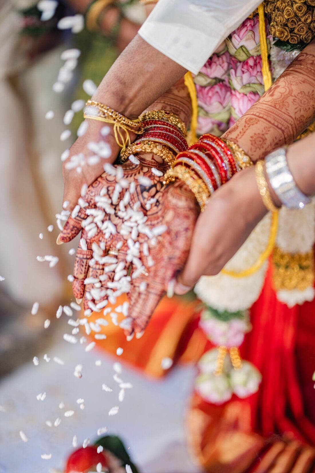 Detail shot of mehndi-adorned hands during the akshintalu ritual