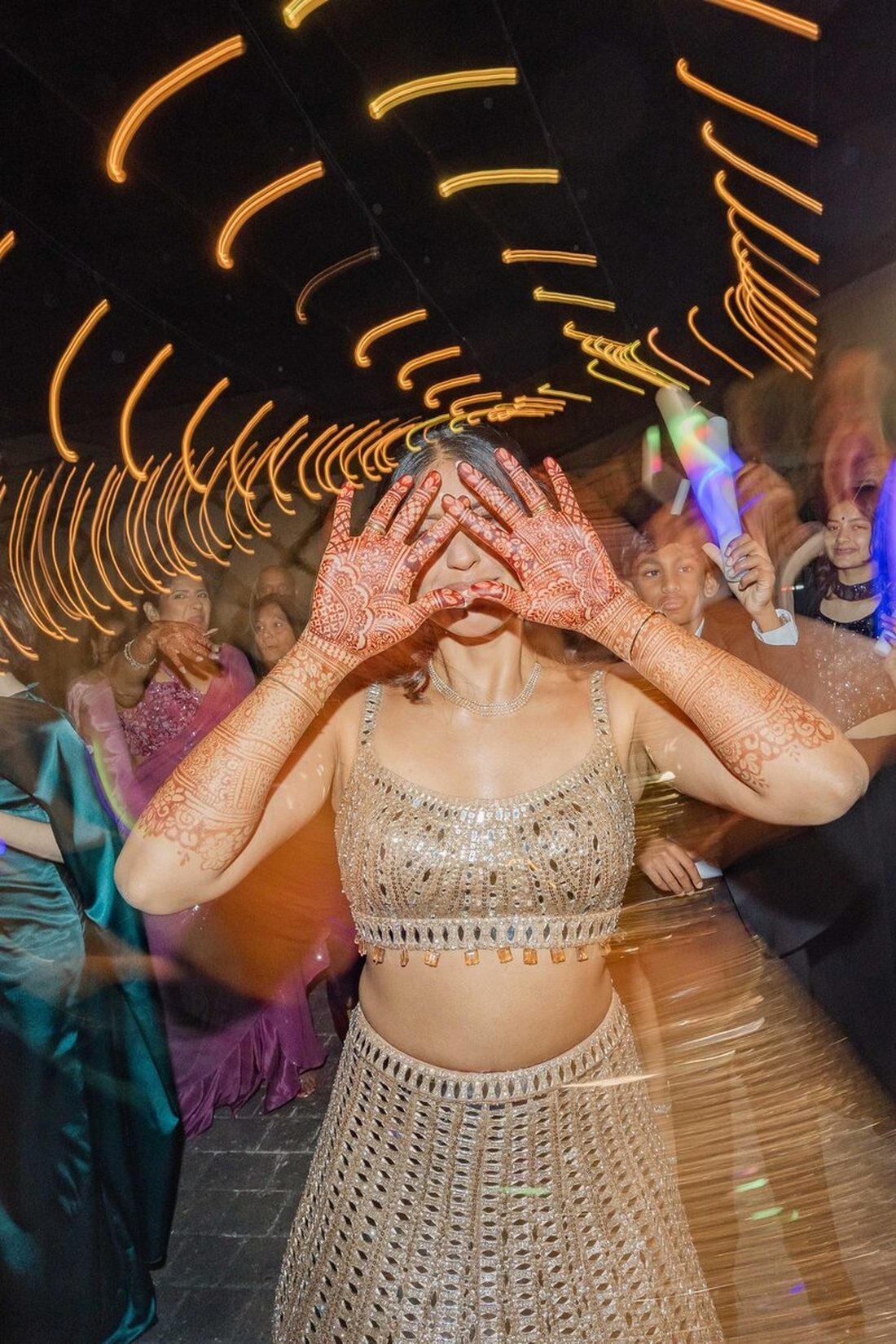 Close-up of a bride's mehndi-adorned hands at the reception