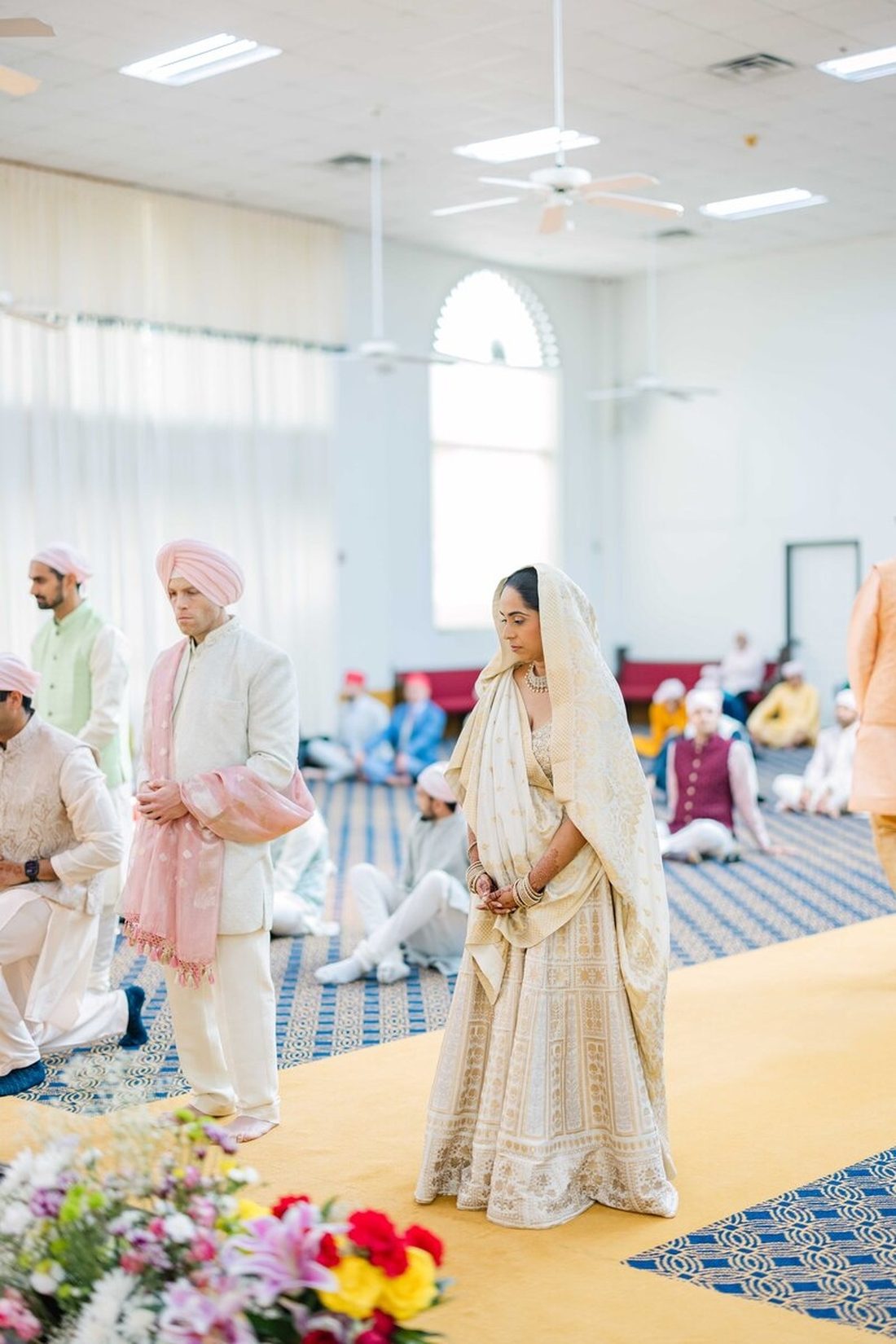 Bride and groom in cream attire during a serene Sikh wedding ceremony
