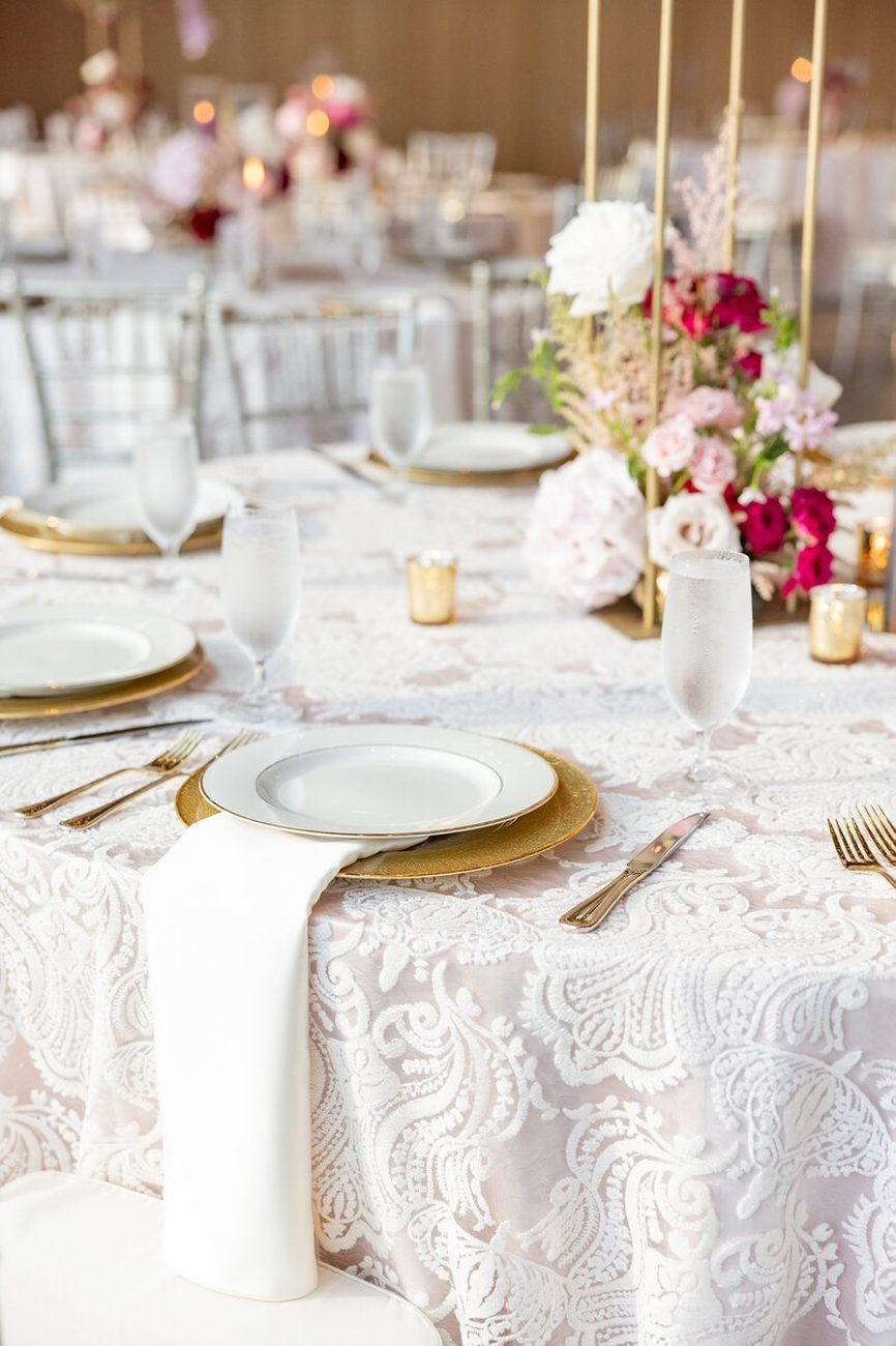 Gold charger on lace linen with cascading florals